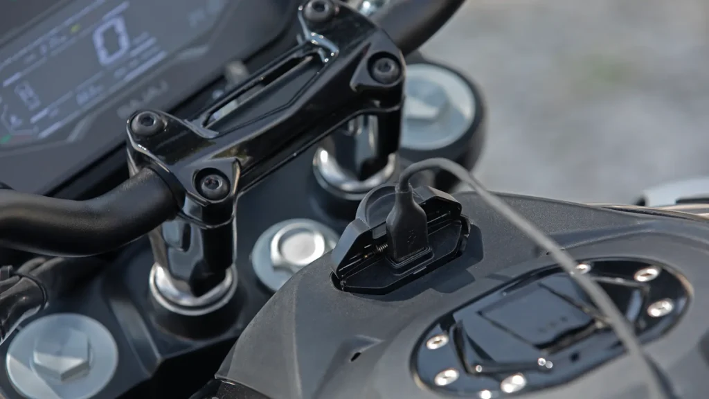 Entrada USB da Bajaj Dominar 250 2027 junto ao guidão.