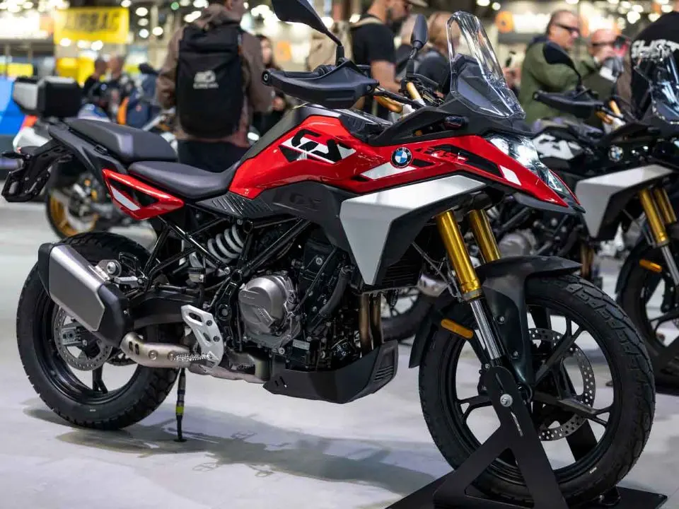 BMW F 450 GS vermelha, branca e preta exibida em vista lateral dianteira.